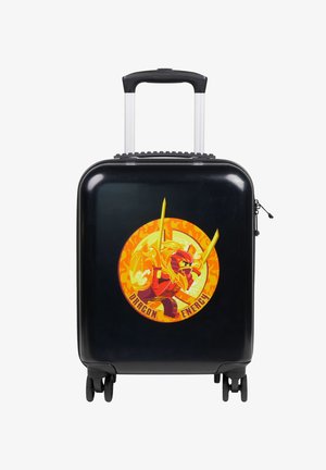 Maleta dura negra con un gráfico que presenta un ninja rojo y llamas amarillas. Incluye un mango retráctil y cuatro ruedas.