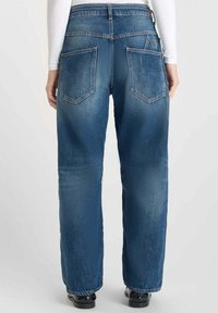 Jean en denim de bleu moyen avec une coupe droite. Comprend deux poches arrière et une taille haute. Texture lisse avec un léger délavage.
