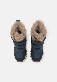 Marineblauwe winterlaarzen met een zachte bruine nepbontvoering, verstelbare klittenbandsluiting en een geweven rubberen zool voor grip.