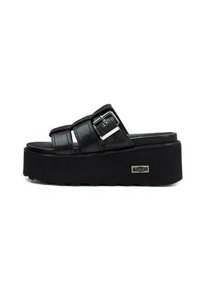 Sandali platform neri con tre cinturini regolabili, accessori in metallo argentato e suola in gomma texturizzata. Presenta un dettaglio del logo sul lato.