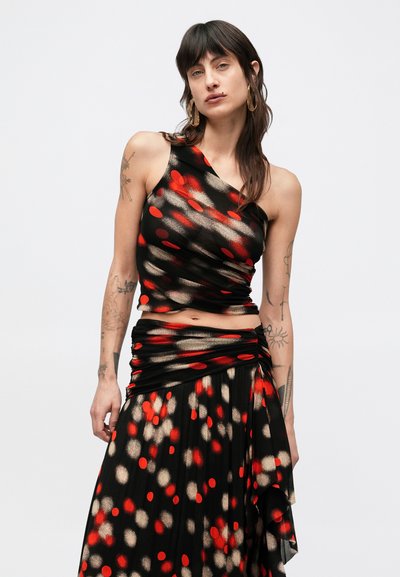 Črni komplet obleke z enoramnim topom in nagubano krilo, okrašen z rdečimi in zlatimi pikami; lahka, gladka tkanina.