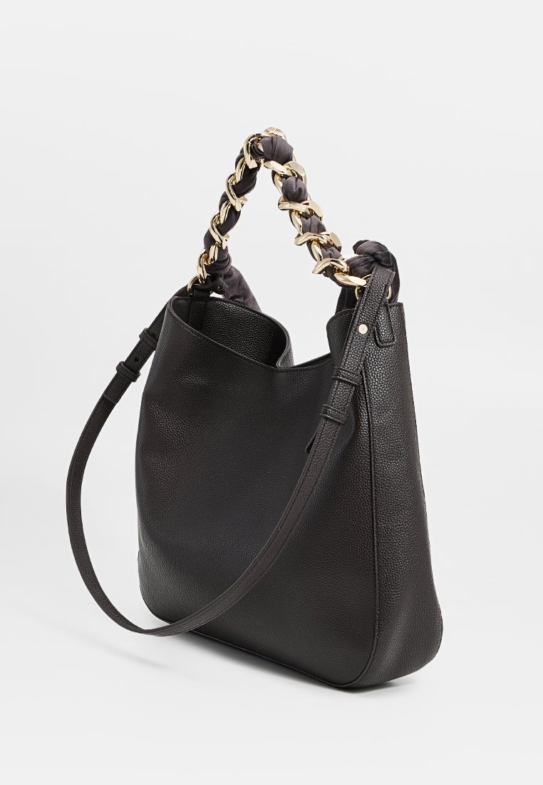 Czarna skórzana torba na ramię o teksturowanym wykończeniu, z unikalnym łańcuchem i materiałowym uchwytem. Zawiera odczepiany pasek na ramię.