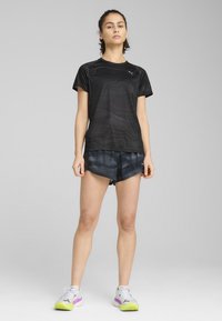 Must-haves must must have must have must have a black athletic t-shirt with a textured pattern, paired with black shorts featuring a subtle sheen. White and purple sneakers with green accents.