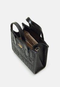 Sort kunstlæder taske med præget logo, åben top, to håndtag og en gylden accent. Indvendigt har den en lys foring og en lynlåslomme.