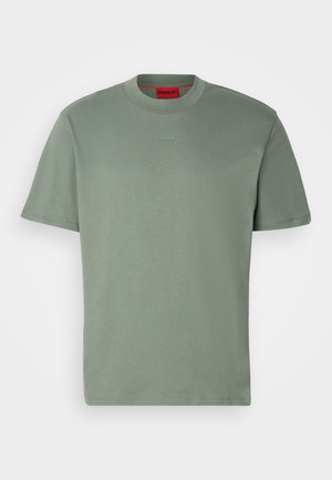 Vihreä puuvillapaita, pyöreä kaula-aukko, lyhyet hihat, etuosassa kohokuvioitu "HUGO" -logo samaa sävyä. Sujuva pinta.