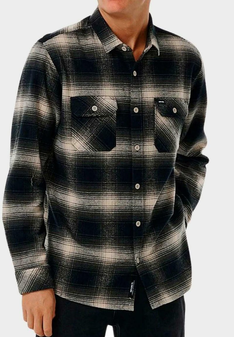 Camisa de franela a cuadros en blanco y negro con dos bolsillos en el pecho, cuello abotonado y mangas largas con un ajuste holgado y tejido texturizado.