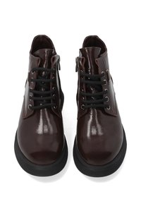 Brązowe lakierowane botki za kostkę z czarnymi sznurowadłami i zapięciem na zamek, z okrągłym noskiem i teksturowaną czarną gumową podeszwą.