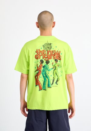 Neon green cotton t-shirt featuring a colorful graphic of three dancing figures and a disco ball on the back. Short sleeves and relaxed fit.