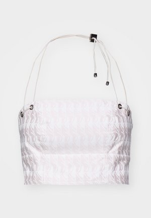 Top cropped blanc avec un motif discret en répétition. Équipé de bretelles réglables et de détails en métal argenté. Tissu lisse et léger.