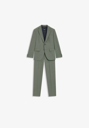 Completo verde chiaro, caratterizzato da un tessuto strutturato, vestibilità su misura e una giacca a due bottoni con rever a lista. Fodera blu navy visibile all'interno.