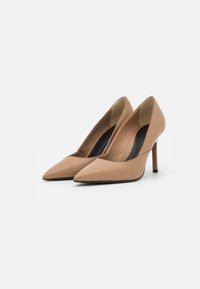 Décolleté in pelle nuda con punta affusolata, texture liscia e tacco stiletto sottile, caratterizzati da un design elegante senza decorazioni.