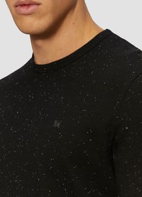Czarny bawełniany sweatshirt z nakrapianym wzorem w białe kropki, z okrągłym dekoltem oraz małym czarnym logo na piersi.