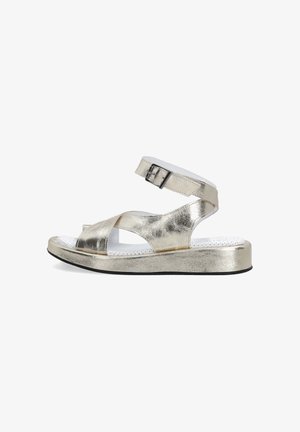 Metallic guld sandaler med et krydsdesign, der har en justerbar ankelrem og en tekstureret hvid indersål. Flad sort sål.