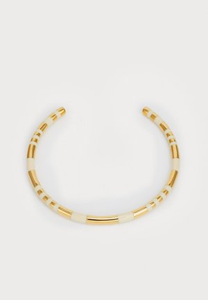 Gold and ivory cuff bracelet featuring alternating striped patterns with smooth and textured sections, creating a curved, open design.