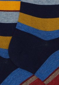 Calzini a righe colorate con strisce blu, navy, gialle e grigie di varie larghezze, realizzati in un tessuto morbido e strutturato.
