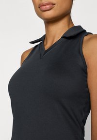 Μαύρο μαν sleeveless πόλο τοπ με V-λαιμόκοψη και διπλωμένο γιακά. Λείος υφή και εφαρμοστό σχέδιο. Χωρίς ορατά μοτίβα ή μεταλλικές λεπτομέρειες.