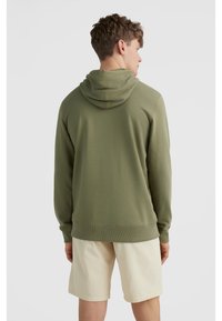 Olivově zelená mikina s kapucí na stažení a vroubkovanými manžetami, spárovaná s béžovými šortkami. Má hladkou texturu a jednoduchý design.