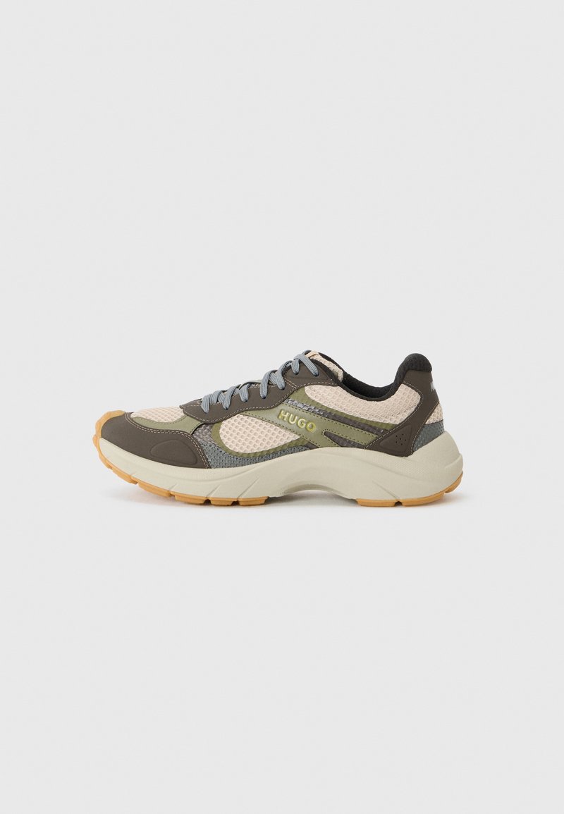 Sneaker mit einem Obermaterial aus Mesh in Beige, Braun und Grau, mit einer robusten Sohle und gelben Akzenten. Schnürverschluss mit Logo-Detail an der Seite.