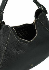 Borsa a mano in pelle nera con superficie testurizzata, forma curva, chiusura superiore con cerniera e cuciture a contrasto. Interno con numerose tasche.