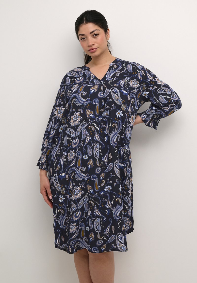 Vestido azul marino con un estampado de paisley en varios colores, mangas largas con puños elásticos y escote en V. Tejido ligero.