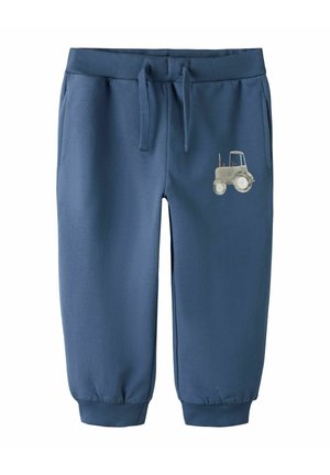 Pantalon de survêtement bleu pour tout-petit avec des poignets côtelés, une taille à cordon, des poches latérales et un petit motif de tracteur gris sur la cuisse droite.