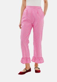 Růžové kalhoty s kostkovaným vzorem a volánkovým detailem na lemu, s volným střihem a bočními kapsami. Nosit s červenými balerínami.