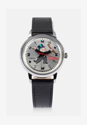 Orologio Timex con quadrante argentato che presenta un personaggio di Monopoly, numeri neri e simboli. Cinturino in pelle nera, cassa rotonda in acciaio inossidabile.