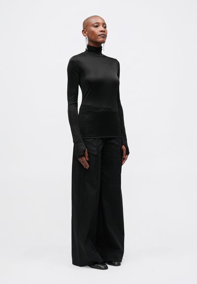 Culoare neagră, bluză cu mâneci lungi și guler înalt, asortată cu pantaloni largi negri. Ambele articole au o textură netedă �și un design minimat.