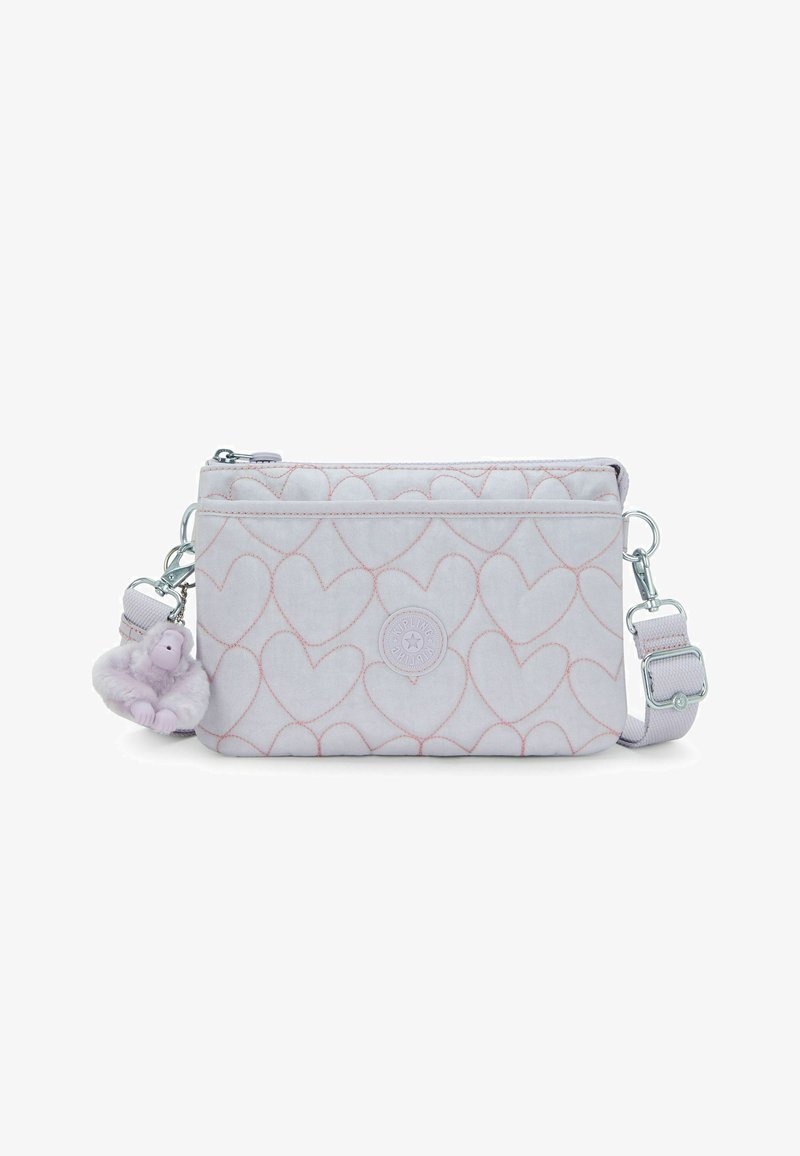 Vaaleanpunainen, tikattu olkalaukku sydänompeleilla, edessä vetoketjutasku, säädettävä remmi ja pehmeä apinakuvallinen avaimenperä.