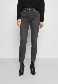 Höga, slim fit jeans i mörk denim med en subtil textur, med detaljer i koppar på knapparna och ankellång längd som är parat med svarta stövlar.