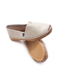 Espadrillas in tela beige con suola in juta intrecciata, caratterizzate da un accento cucito sulla punta e una suola in gomma flessibile per una buona aderenza.