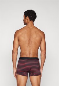 Svarta boxershorts för män med röda horisontella ränder, åtsittande design, elastiskt midjeband och mjuk textur. Visar baksidan.
