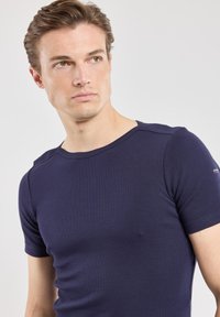 T-shirt navy a maniche corte con collo a giro e dettagli sulle cuciture delle spalle. Texture morbida e design aderente.