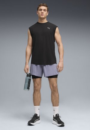 Camiseta negra sin mangas, pantalones cortos morados, zapatos deportivos negros, sosteniendo una botella de agua transparente. Diseño minimalista con acentos del logo de Puma.