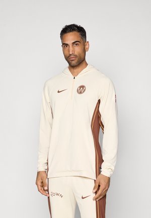 Cremefarvet hætte sweatshirt med brune detaljer og sidelister, der har en lynlåskrave og logo på brystet. Glat stoftekstur.