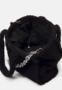 Czarna, pluszowa torba-bucket z fakturowanym wykończeniem, podszewką wewnętrzną i srebrnym łańcuszkiem. Posiada kieszeń na zamek i etykietę z logo wewnątrz.