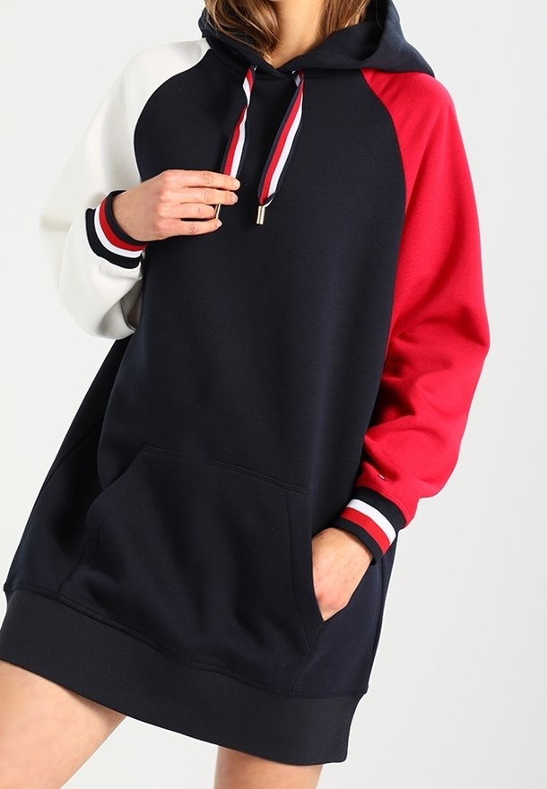 Kapuzensweatkleid in Marineblau, Rot und Weiß. Merkmale sind Raglanärmel, eine Fronttasche und gerippte Bündchen mit Streifenakzenten.