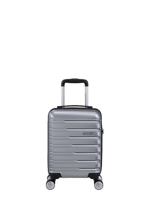 Silberner Hartschalen-Kabinenkoffer mit vier Spinner-Rollen und einem schwarzen, ausziehbaren Griff, vorne mit dem Markenlogo American Tourister.