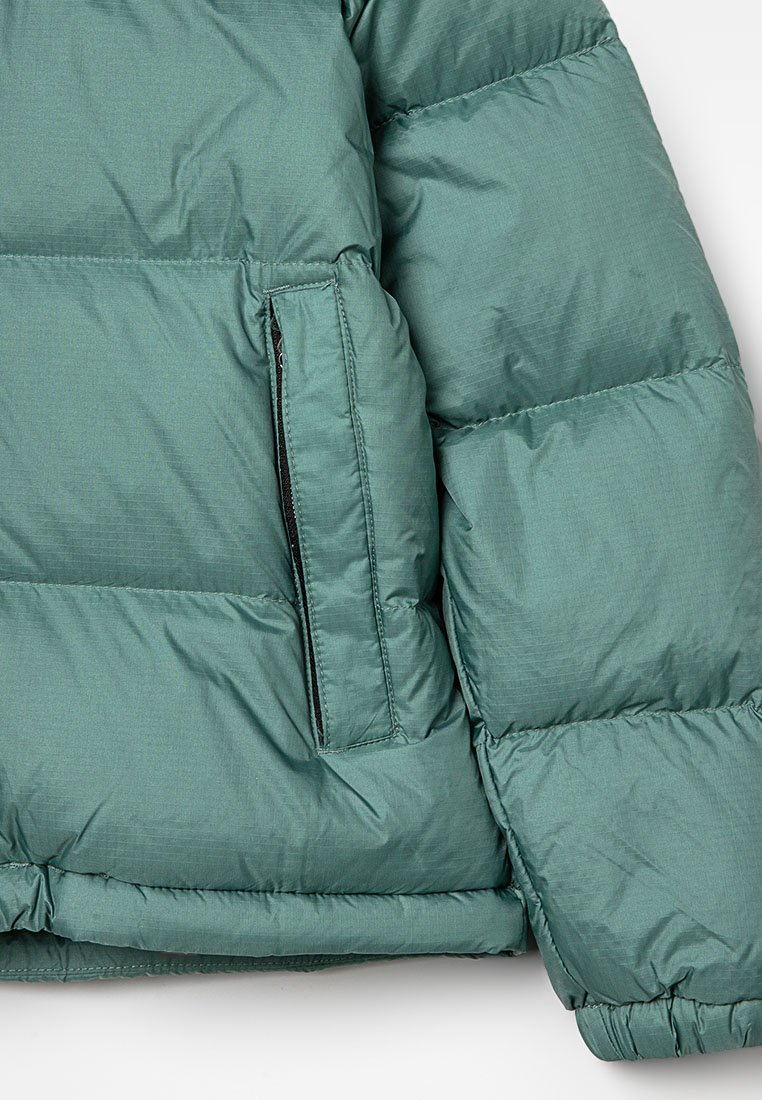 Grüne Pufferjacke mit glattem, glänzendem Außenmaterial, gesteppten Abschnitten und einer Reißverschlusstasche am linken Ärmel.