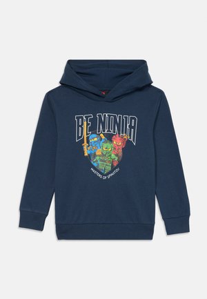 Dunkelblauer Hoodie mit einem Frontdruck, der drei Cartoon-Ninjas zeigt. Der Text lautet "SEI NINJA" und "MEISTER DES SPINJITZU" in fetter Schrift.