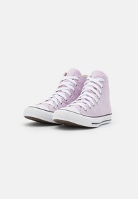 Sneakers de cano alto roxos com atacadores brancos, biqueira de borracha e sola branca com uma faixa preta. Superior em tecido liso com design minimalista.