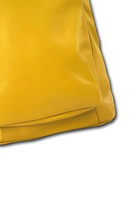 Geel leren tas met een gladde textuur, rechthoekige vorm en een gestructureerde bodem. Heeft gevouwen hoeken en subtiele stiksels.