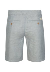 Shorts bleu clair en tissu doux et texturé. Ils comportent une ceinture élastique, deux poches arrière avec boutons en bois, et un ourlet net.