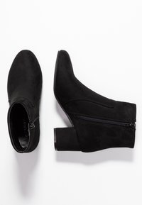 Stivaletti neri realizzati in morbida suede, con zip laterale, punta leggermente appuntita e tacco largo. Design semplice e linee pulite.