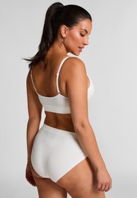 Witte naadloze bralette en high-waisted briefs, met verstelbare banden en een zachte, elastische tailleband met een gladde textuur.