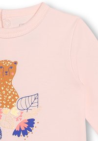 Bodysuit à manches longues rose clair avec un graphique de léopard entouré de motifs floraux colorés. Tissu doux et lisse avec un décolleté rond.