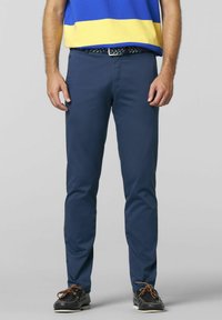 Marineblaue, schlanke Chinos aus leichtem Baumwollmaterial mit glatter Textur und Fronttaschen, kombiniert mit einem gemusterten Gürtel und lässigen Schuhen.