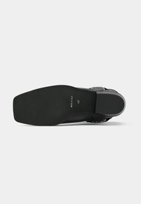 Talpă de pantof neagră cu o formă elegantă și o suprafață texturată. Prezintă un design plat și o imprimare subtilă a logo-ului. Margini netede și fără componente proeminente.