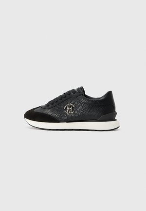 Sneaker noir avec motif texturé en cuir de serpent, bout en suède, design à lacets, semelle blanche et logo métal sur le côté.