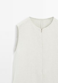 Sleeveless light gray top in a soft, textured fabric with a round neckline and a zip closure at the back. Simple, clean design.
